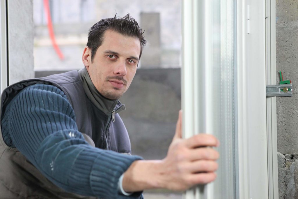 Male worker holding a window frame